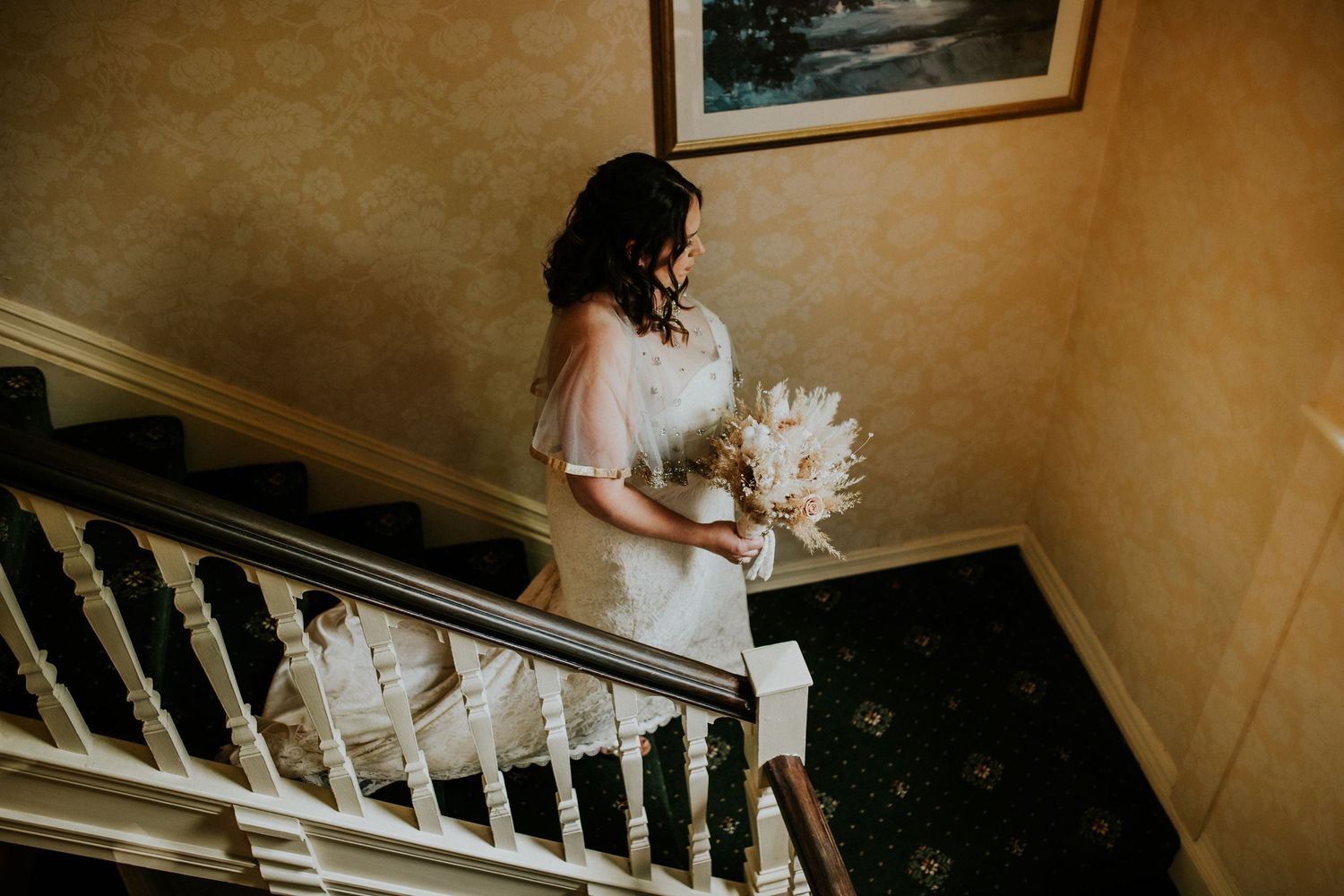 Elegant staircase in a vintage-style wedding venue with white bannisters.