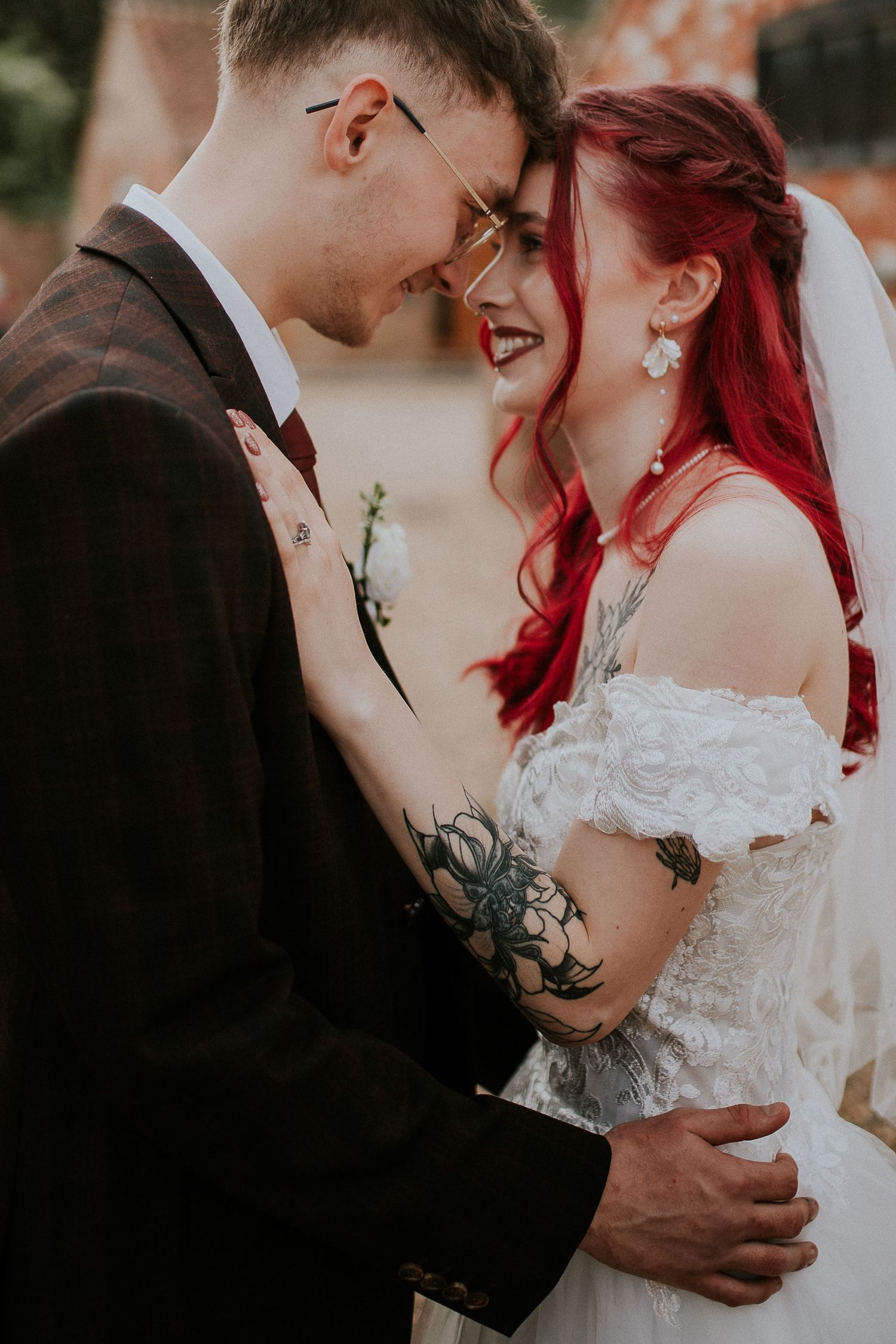 Intimate moment between bride with red hair and groom sharing a close embrace.