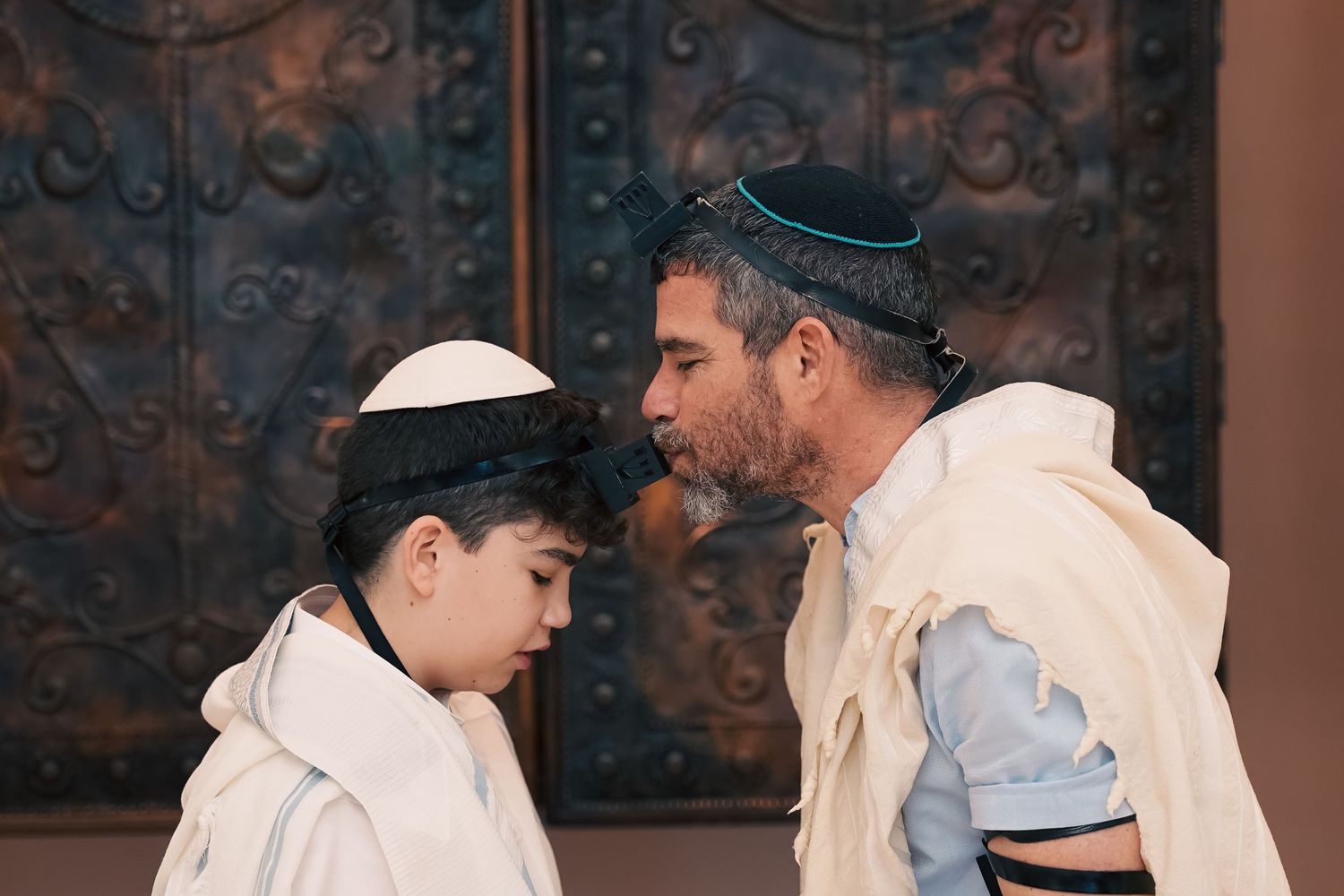 Candid moment captured between family members during a religious celebration.