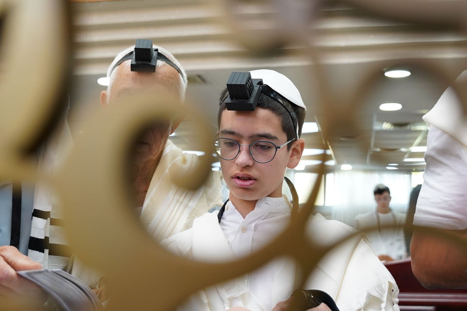 Interior view of religious study session through decorative foreground elements.