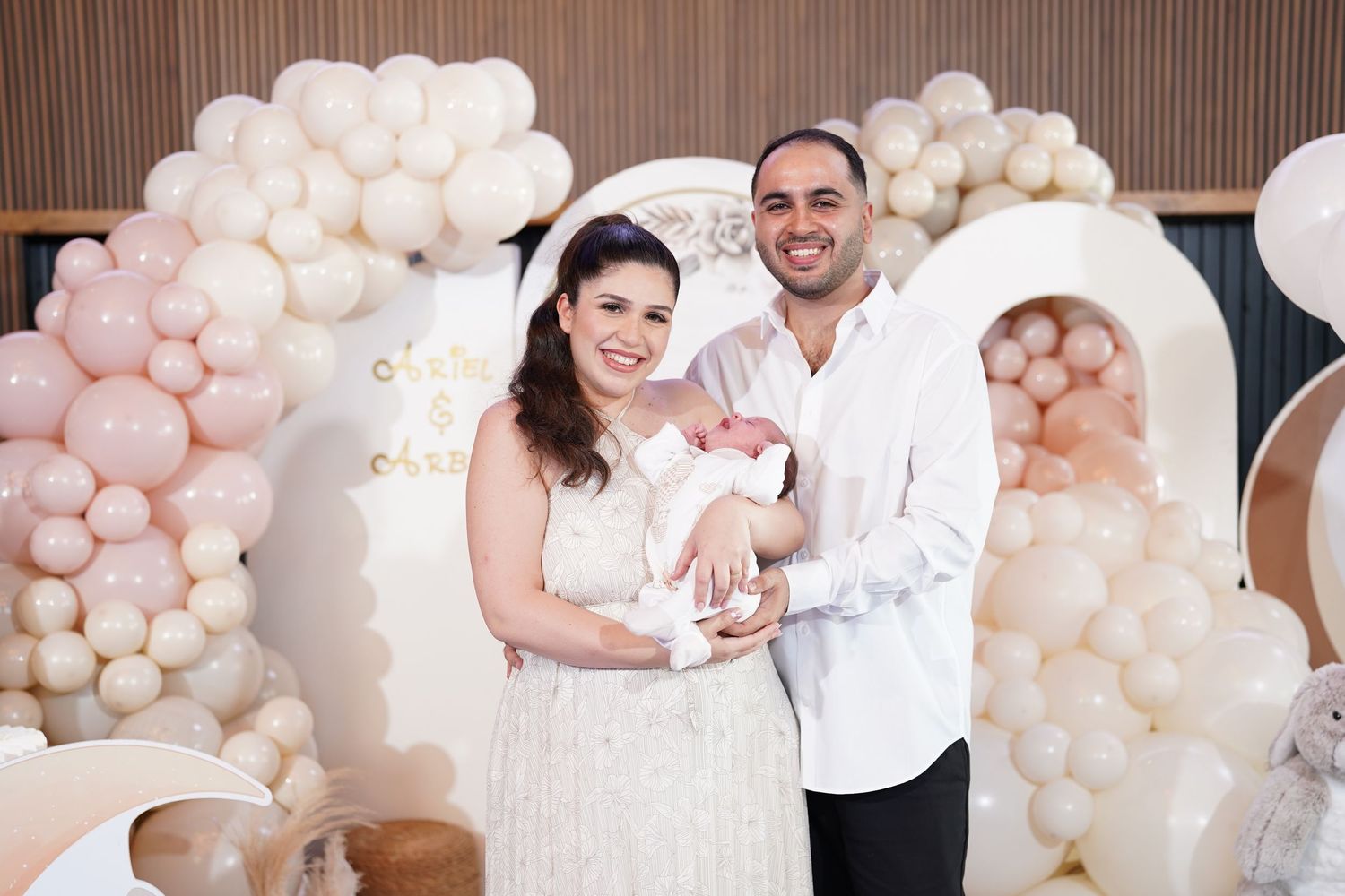 Family celebration with white balloon decorations and elegant indoor setting.