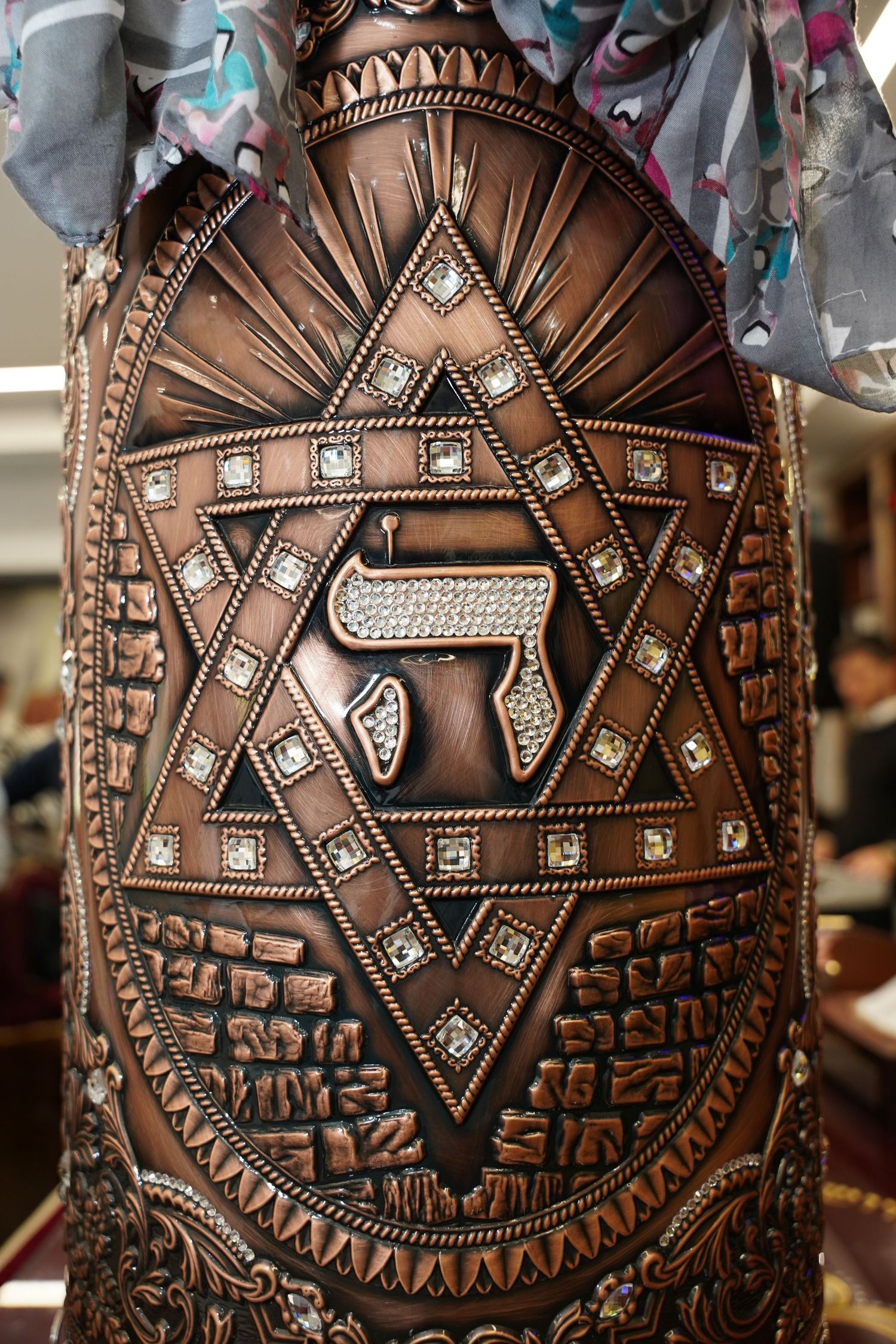 Detailed view of embellished leather Torah case featuring rhinestone accents and geometric designs.