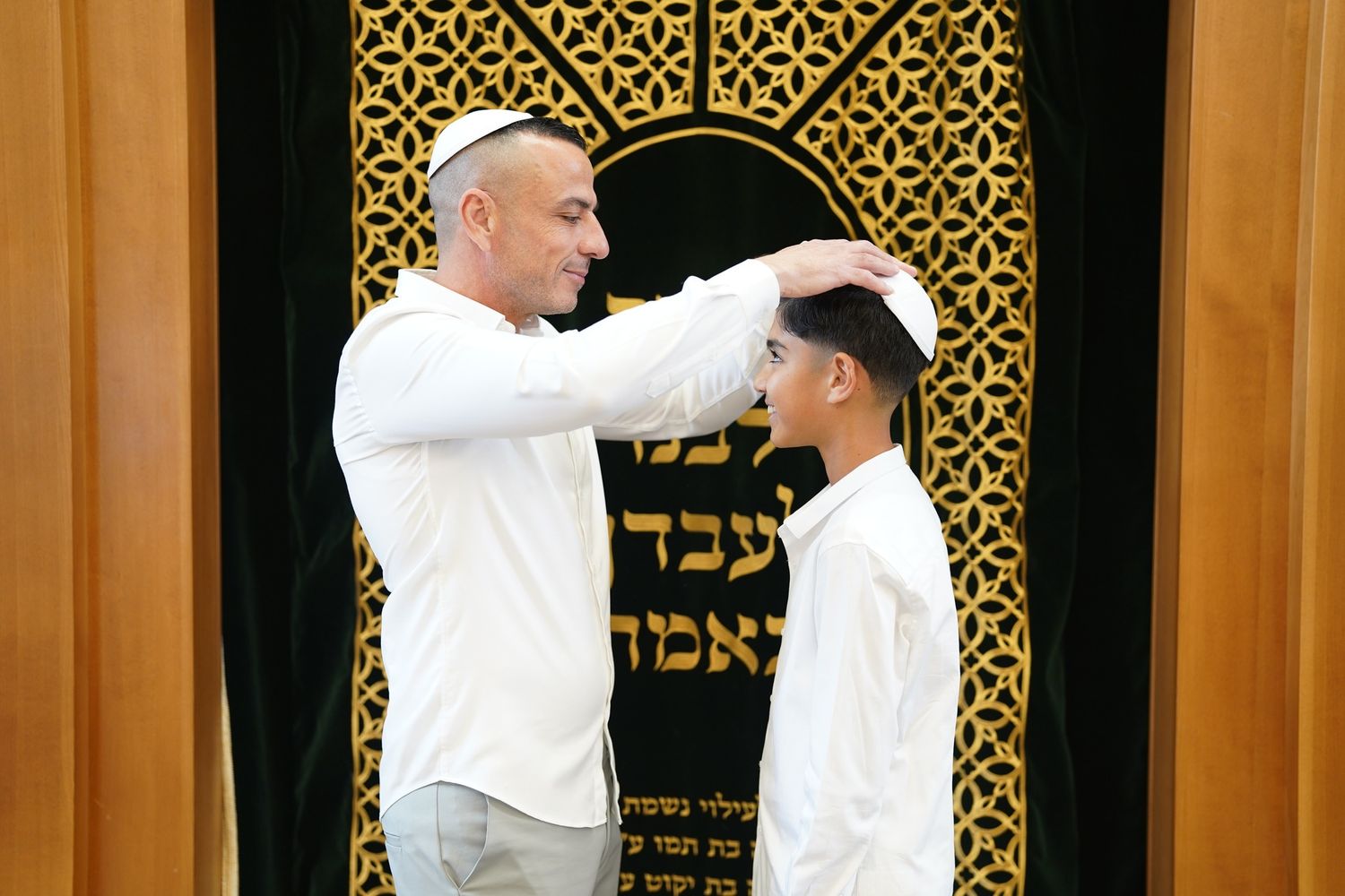 Religious ceremony taking place in front of an ornate gold patterned backdrop.