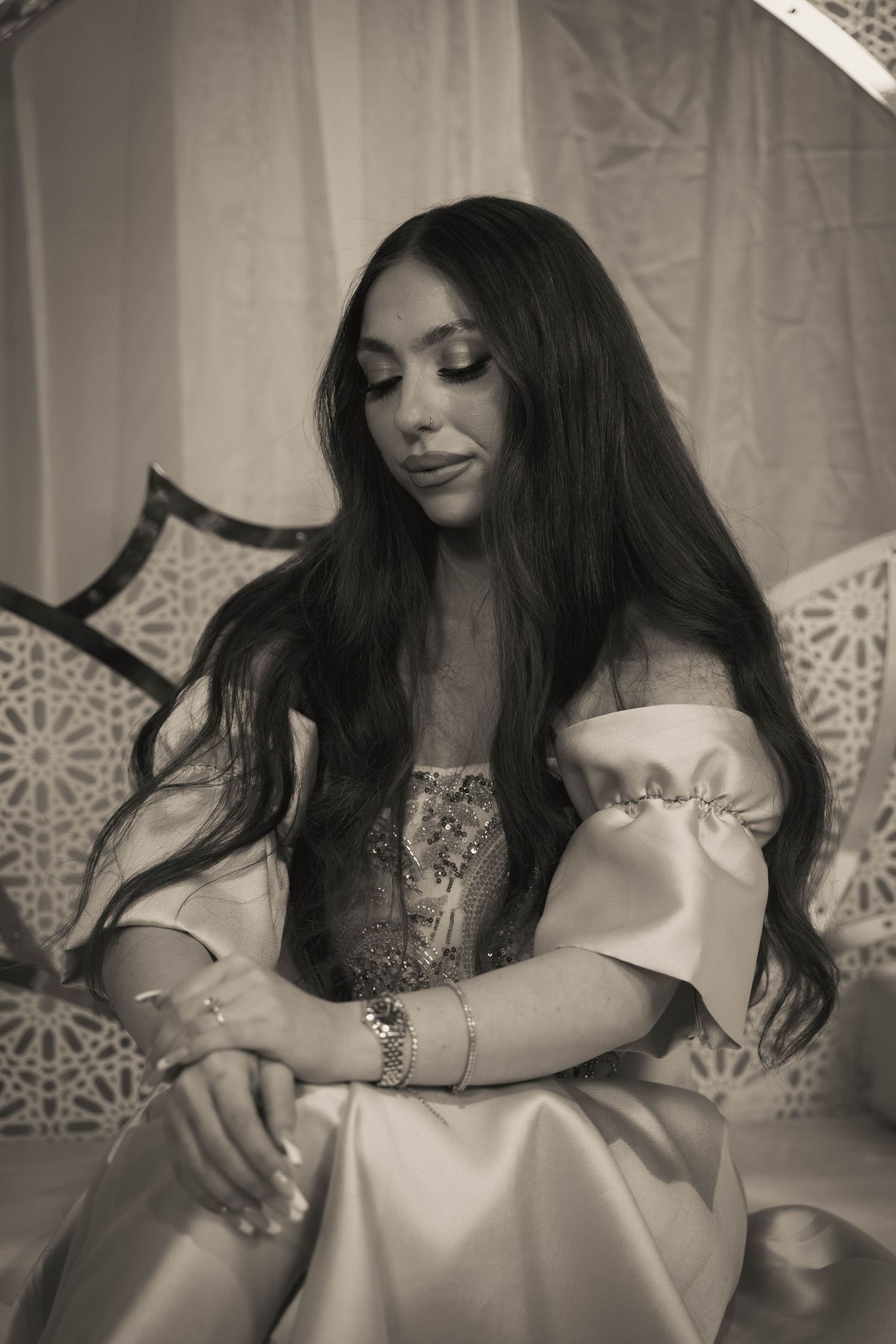 A series of black and white photos showing someone in an elegant white dress looking down in an artistic pose.
