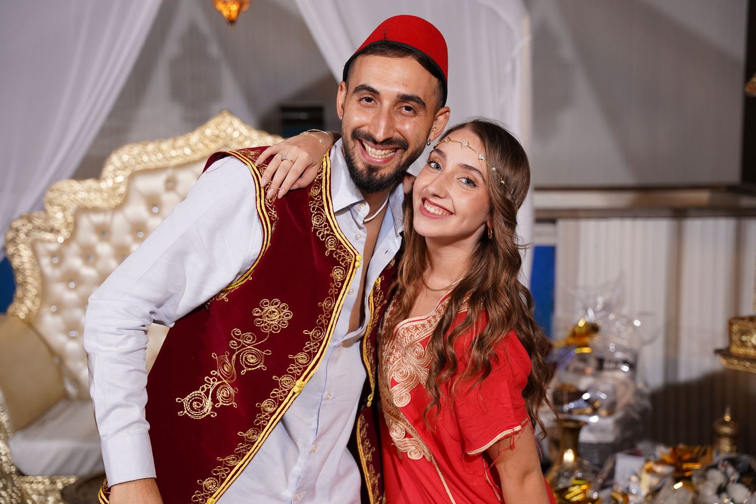 Couple in festive attire enjoying themselves at an elegant celebration.