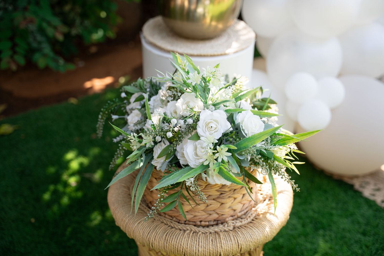 Rustic wedding decor featuring white flowers and natural elements on woven bases.