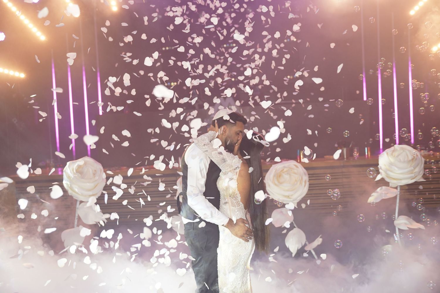 Wedding reception dance floor filled with confetti and dramatic lighting effects.
