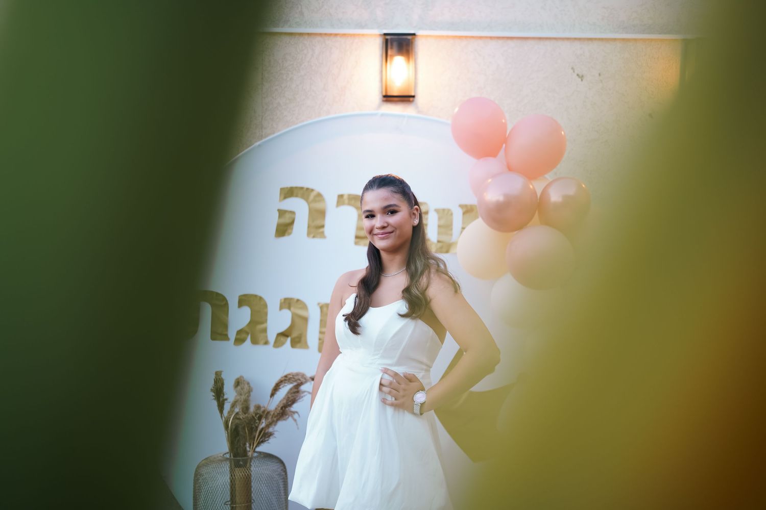 A party setup with pink balloons and decorative elements against a white wall.