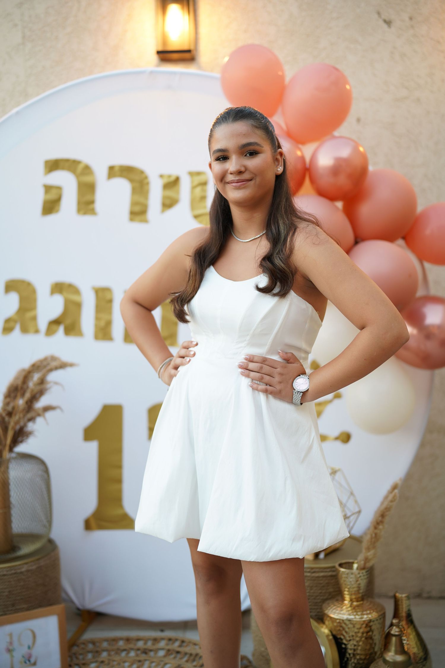 White and coral party decorations featuring balloons and metallic accents.