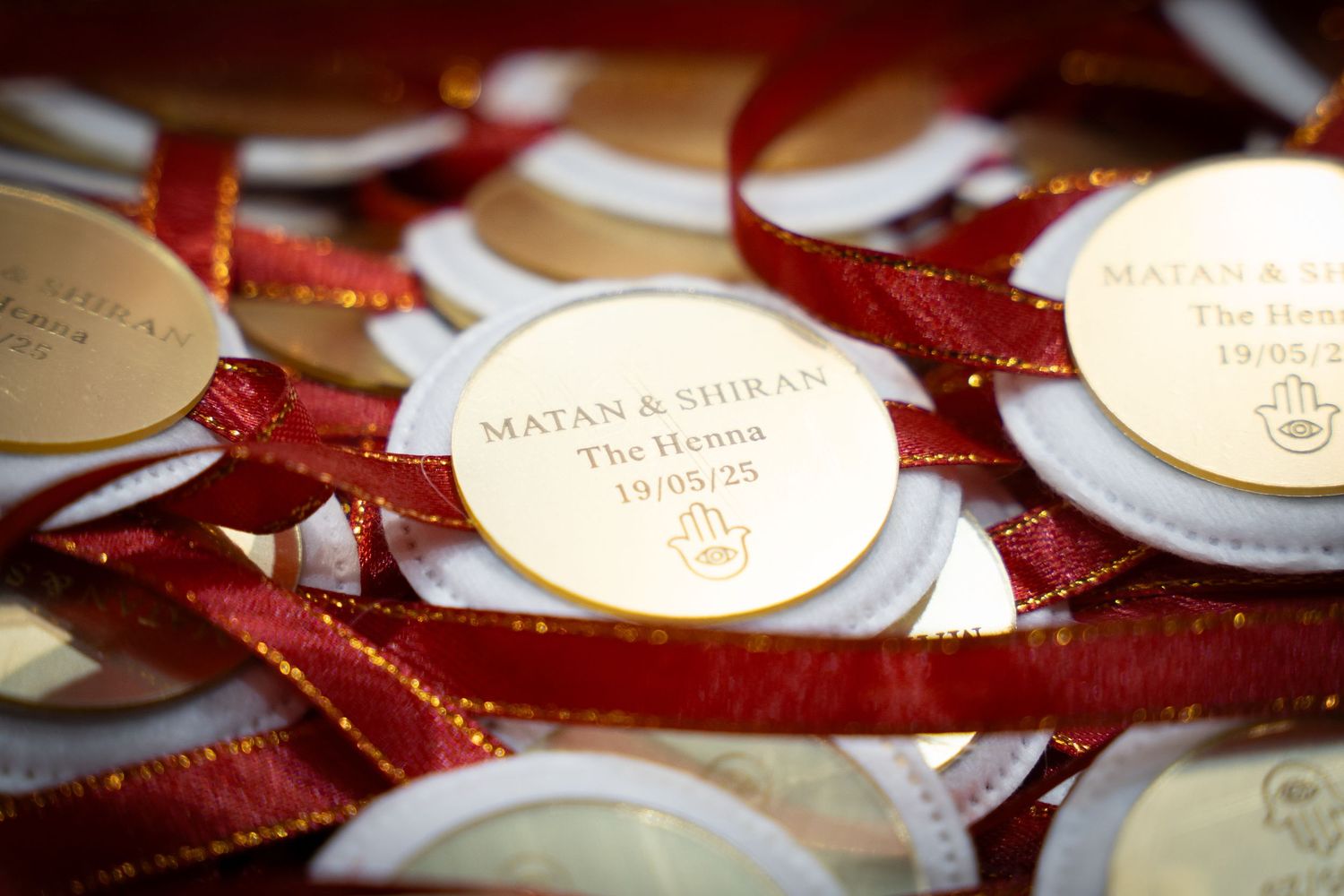 Red velvet ribbons with gold metallic name cards arranged for formal event.