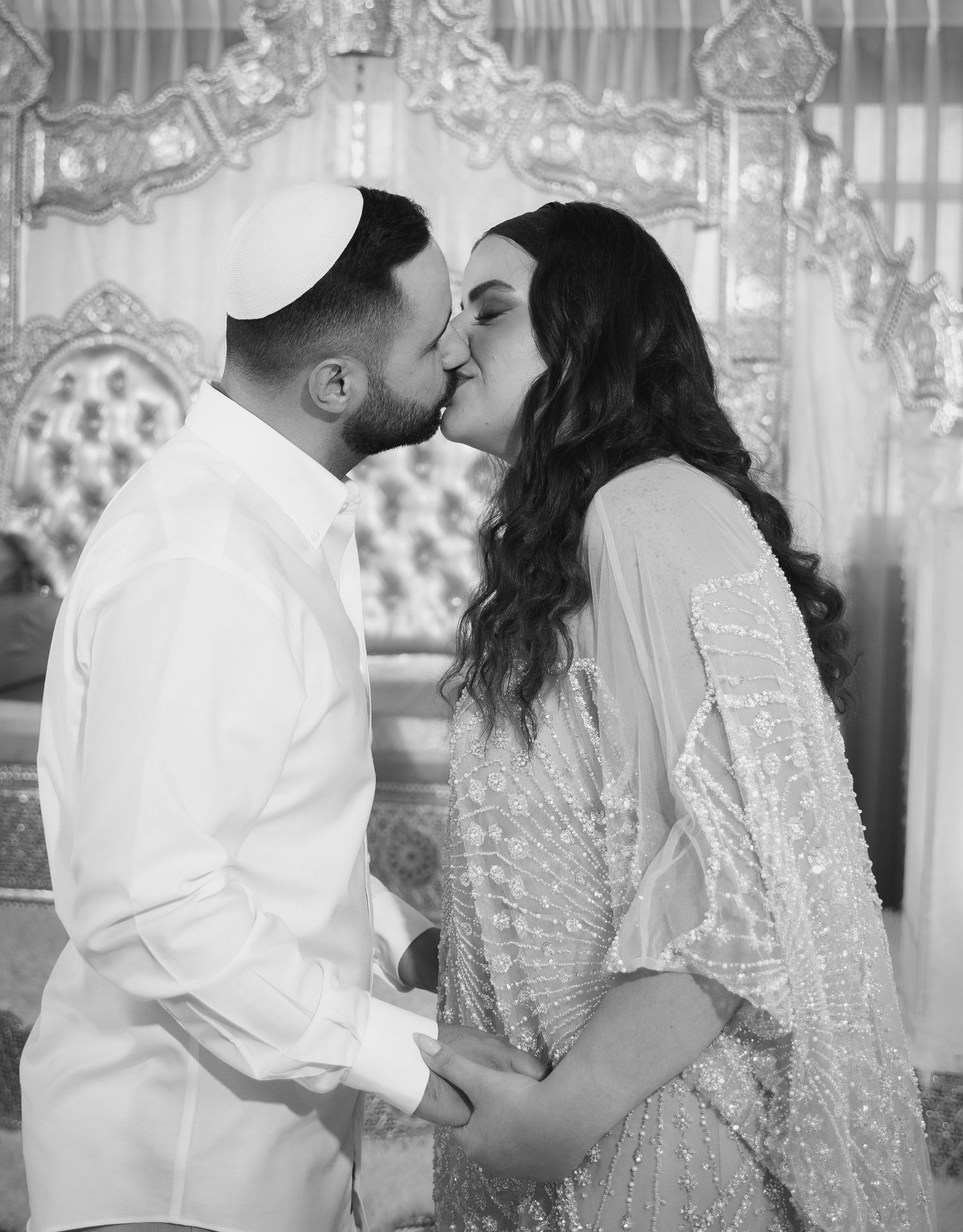 Series of romantic poses between couple in white and sparkly formal wear against ornate backdrop.