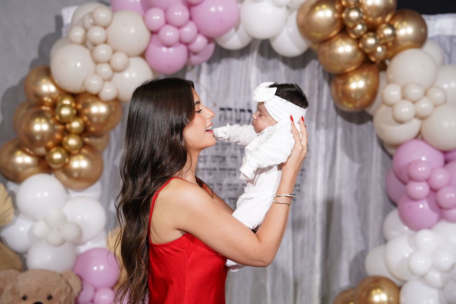 Elegant baby celebration with balloon arch featuring pink, white and gold colors.