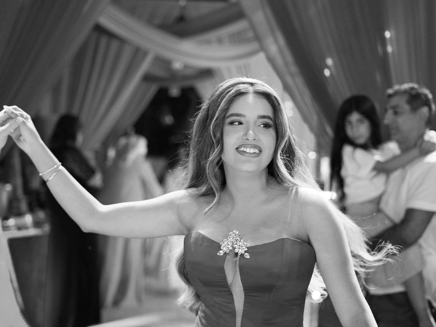 Joyful dance celebration captured in black and white with elegant formal wear.
