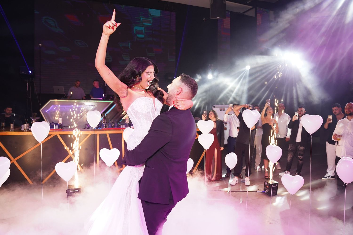 Wedding reception dance floor filled with celebration and purple lighting effects.