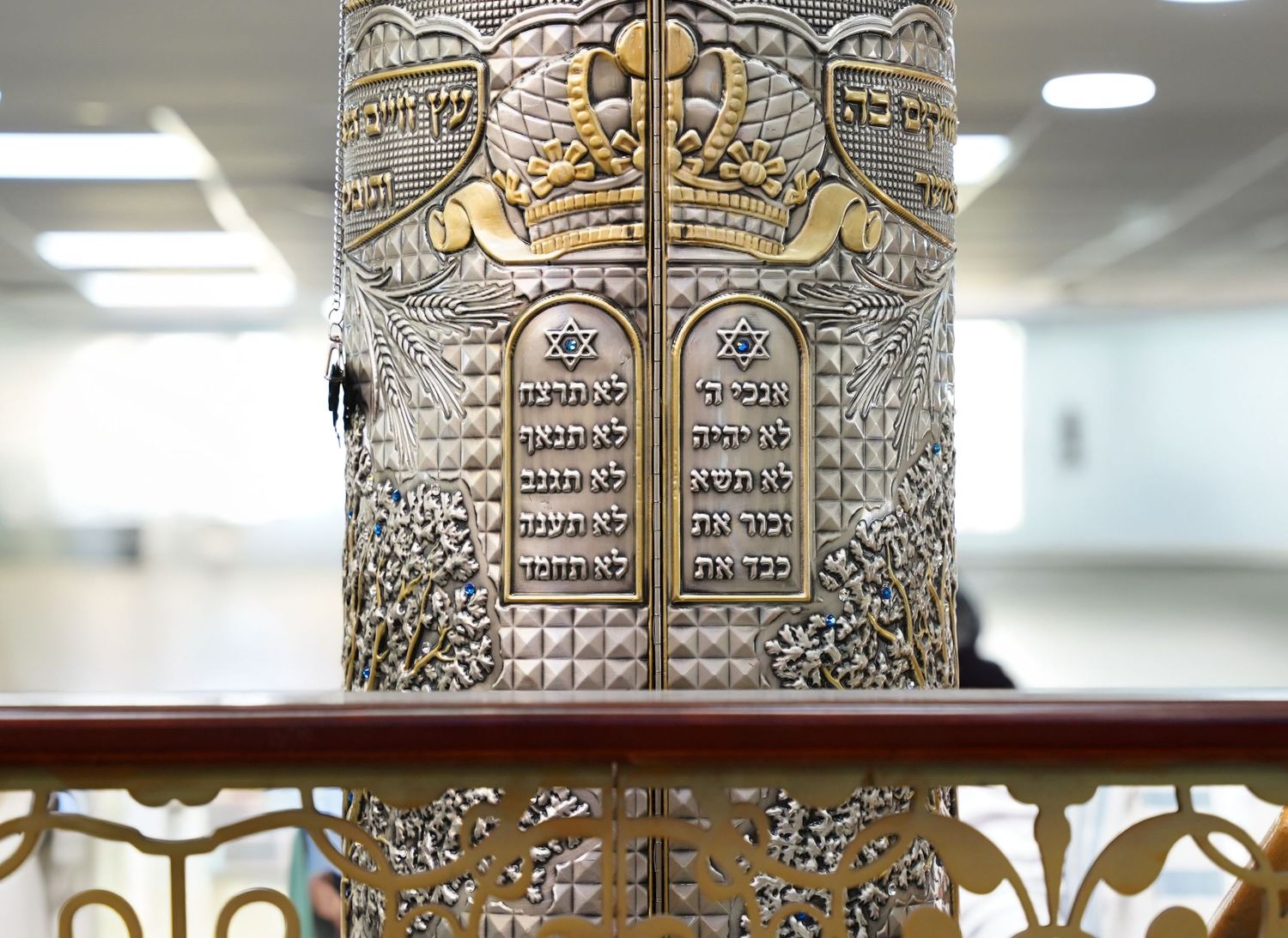 Decorative silver Torah ark with intricate metalwork and Hebrew inscriptions.