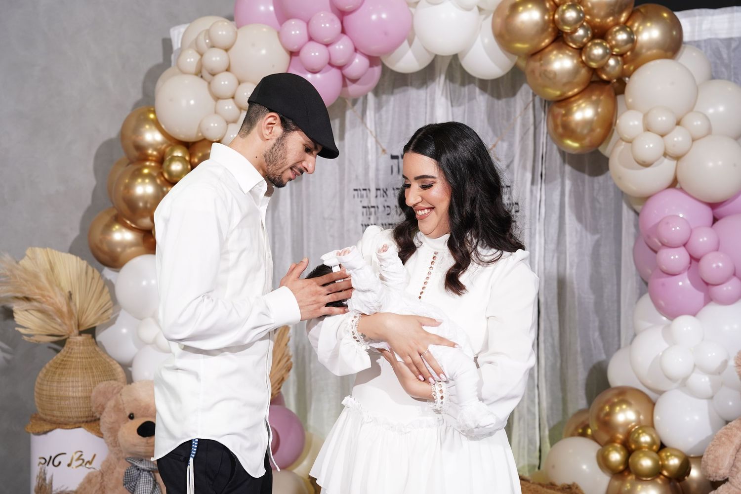 Celebration backdrop with balloon garland in pink, white and gold with stuffed animals.