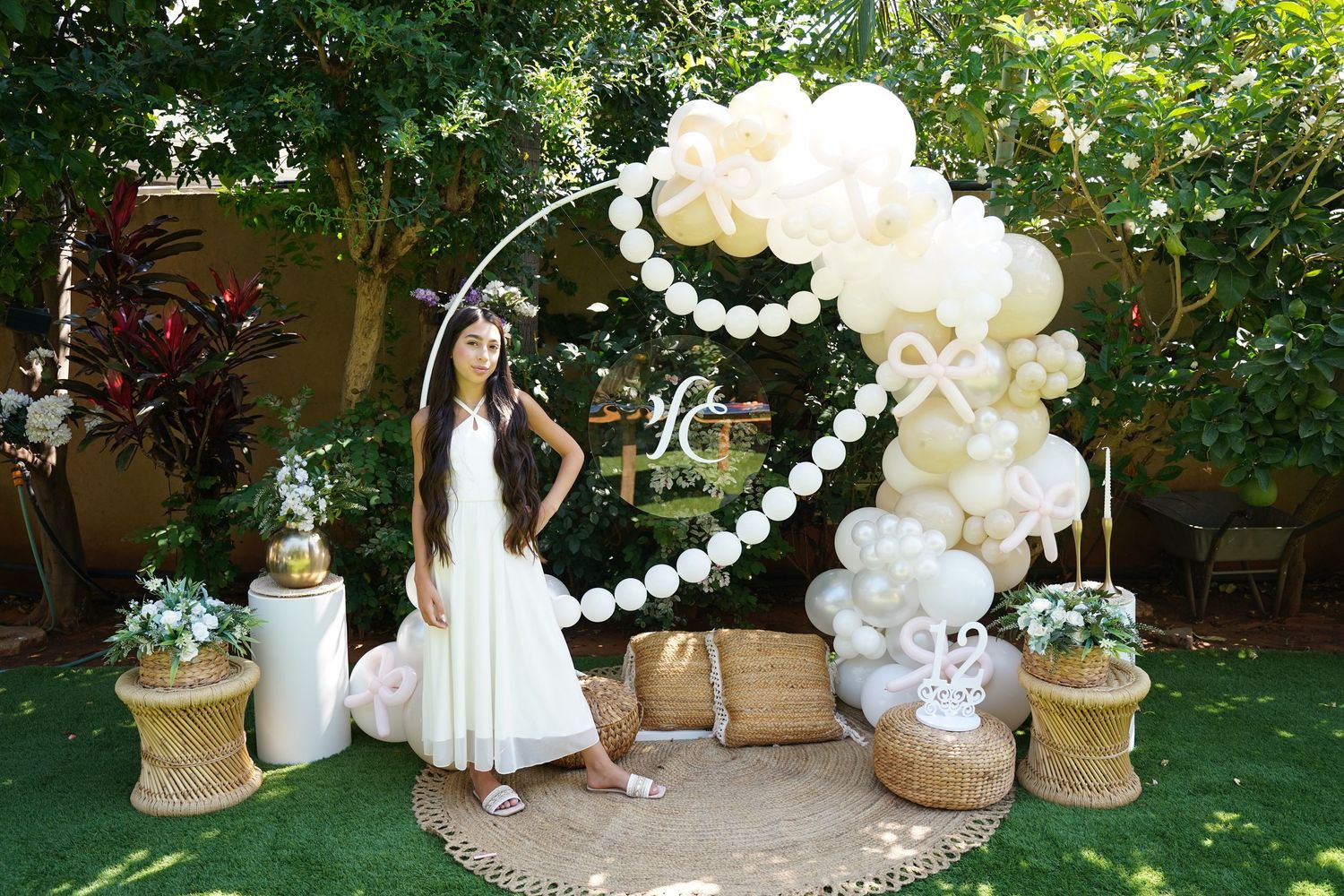Garden party setup with white balloons and rustic decorative elements.