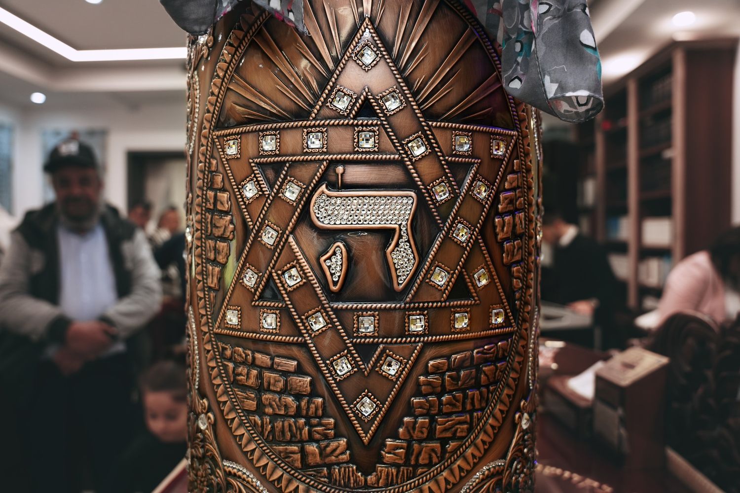 Detailed close-up of an ornate wooden Star of David carving with Hebrew text.