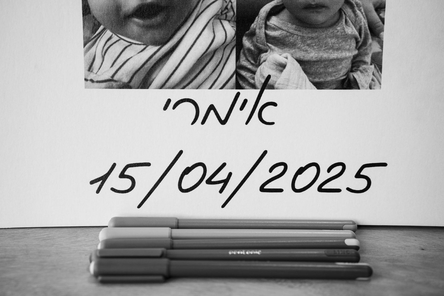 Black and white photo with handwritten date and pens below.