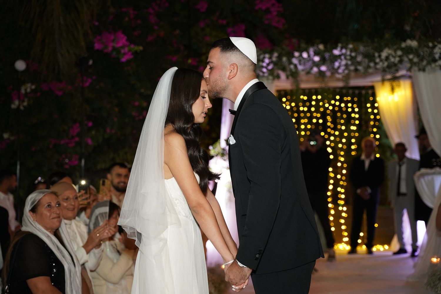Elegant wedding reception venue decorated with twinkling lights and floral arrangements.