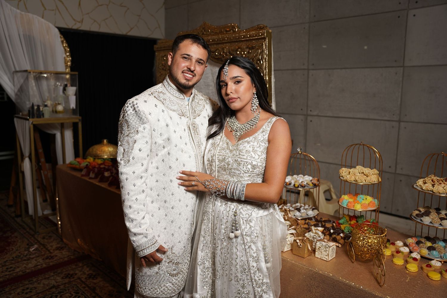 Wedding celebration with elegant decor and dessert table setup.