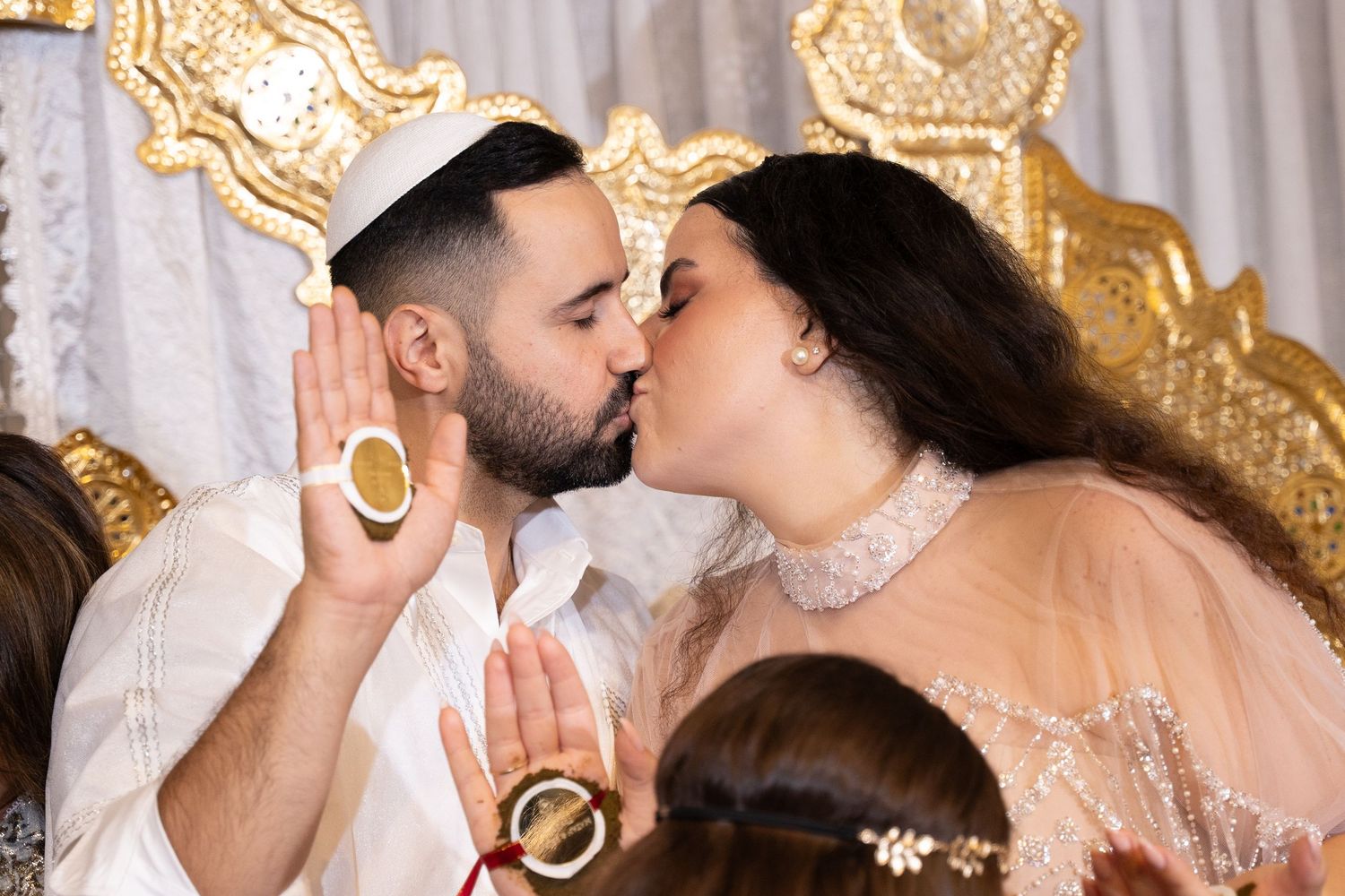 Couple sharing an intimate moment at their celebration with ornate gold decor.