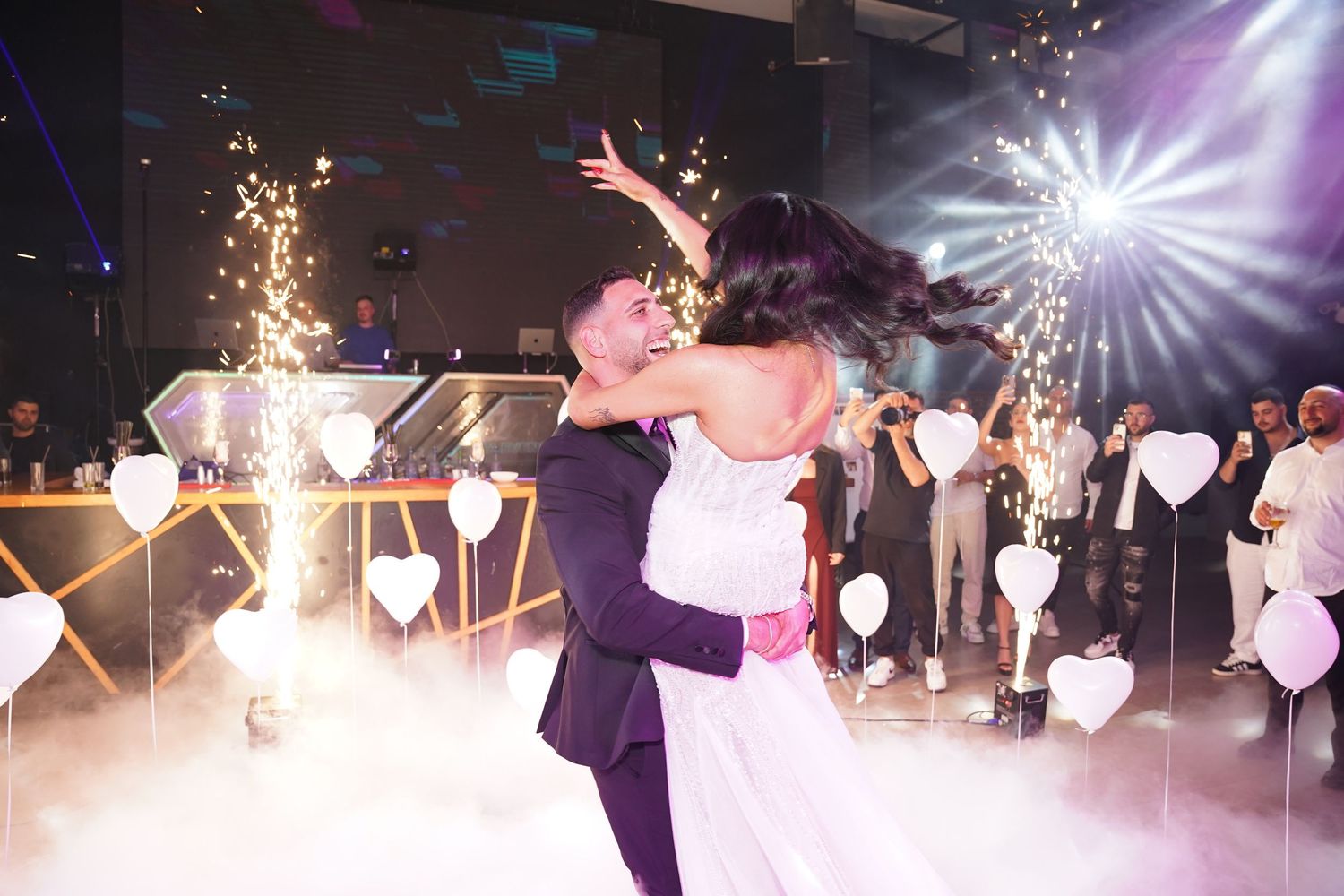 Wedding party celebration with sparklers and dramatic lighting effects on the dance floor.
