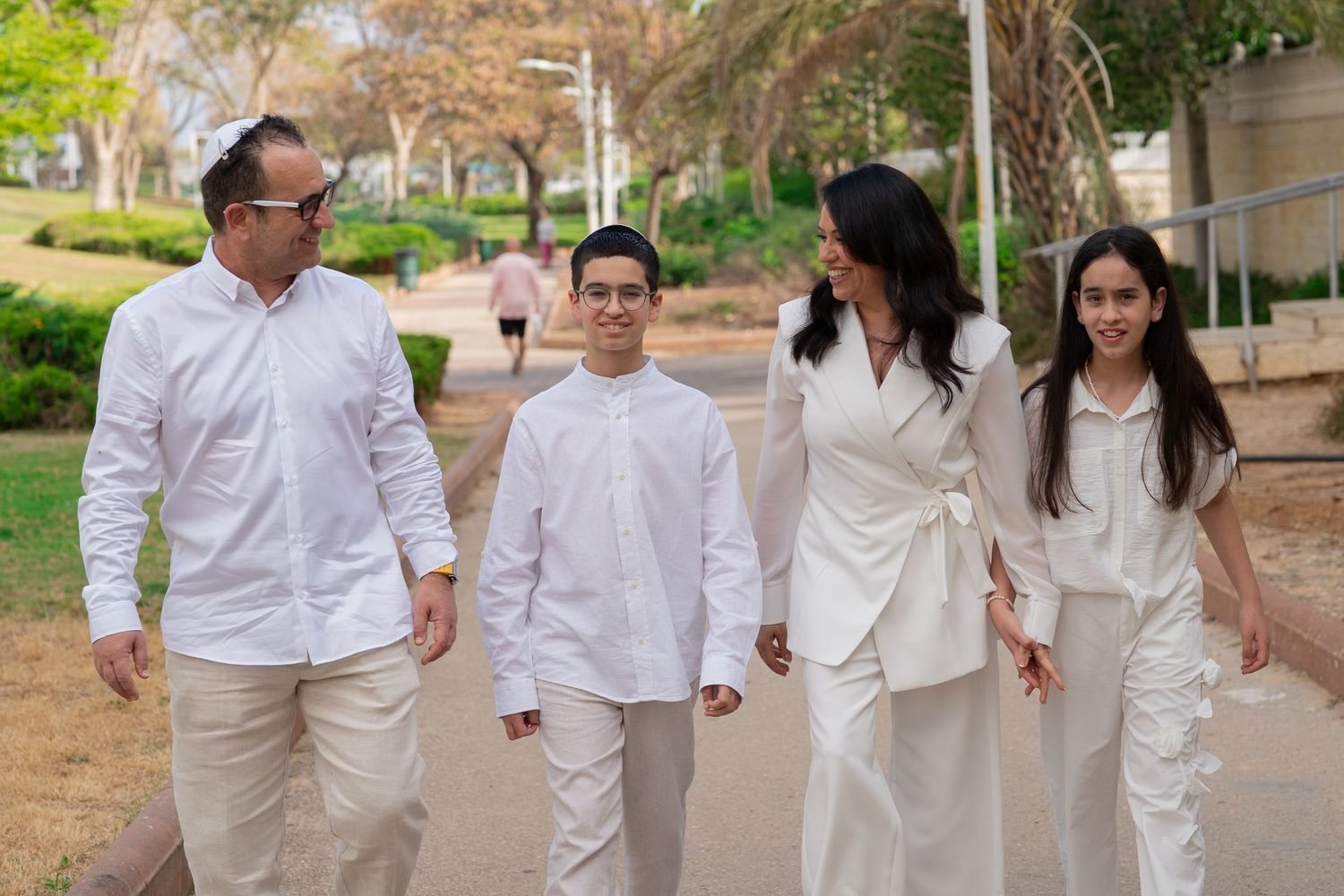 A group walking together outdoors wearing coordinated white outfits.