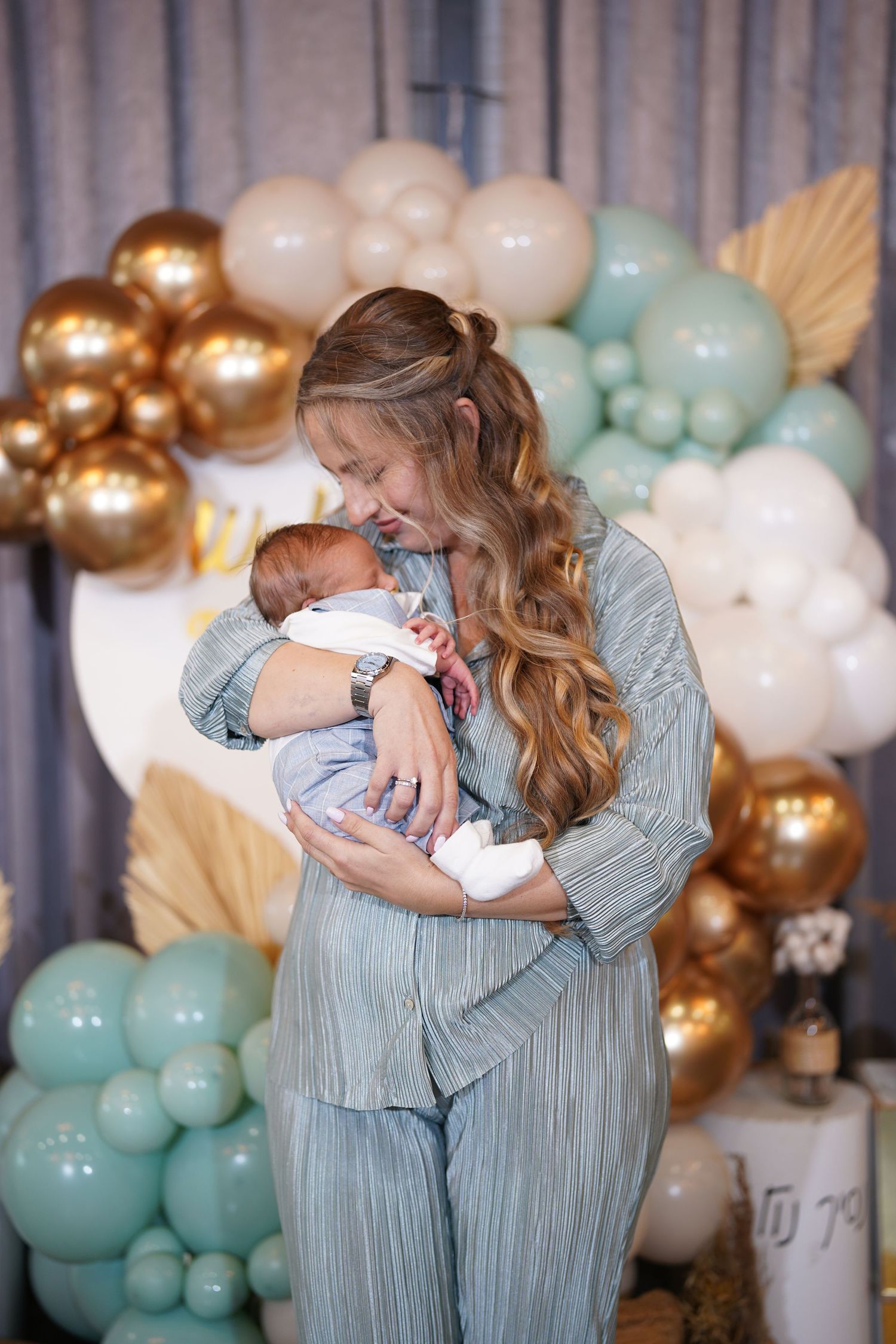 Precious moment shared at an elegantly decorated baby shower with balloon garland.