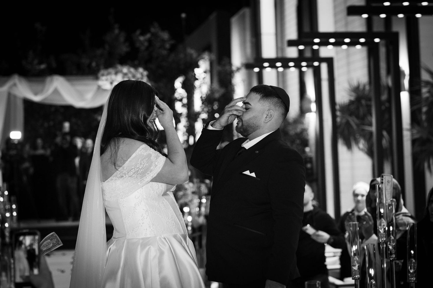 Black and white photo of bride and groom sharing a tender moment at their wedding reception.