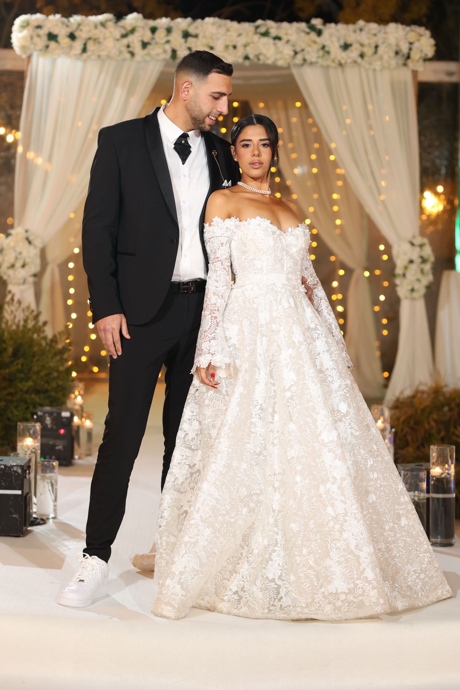 Stunning ballgown wedding dress with off-shoulder lace details against elegant reception decor.