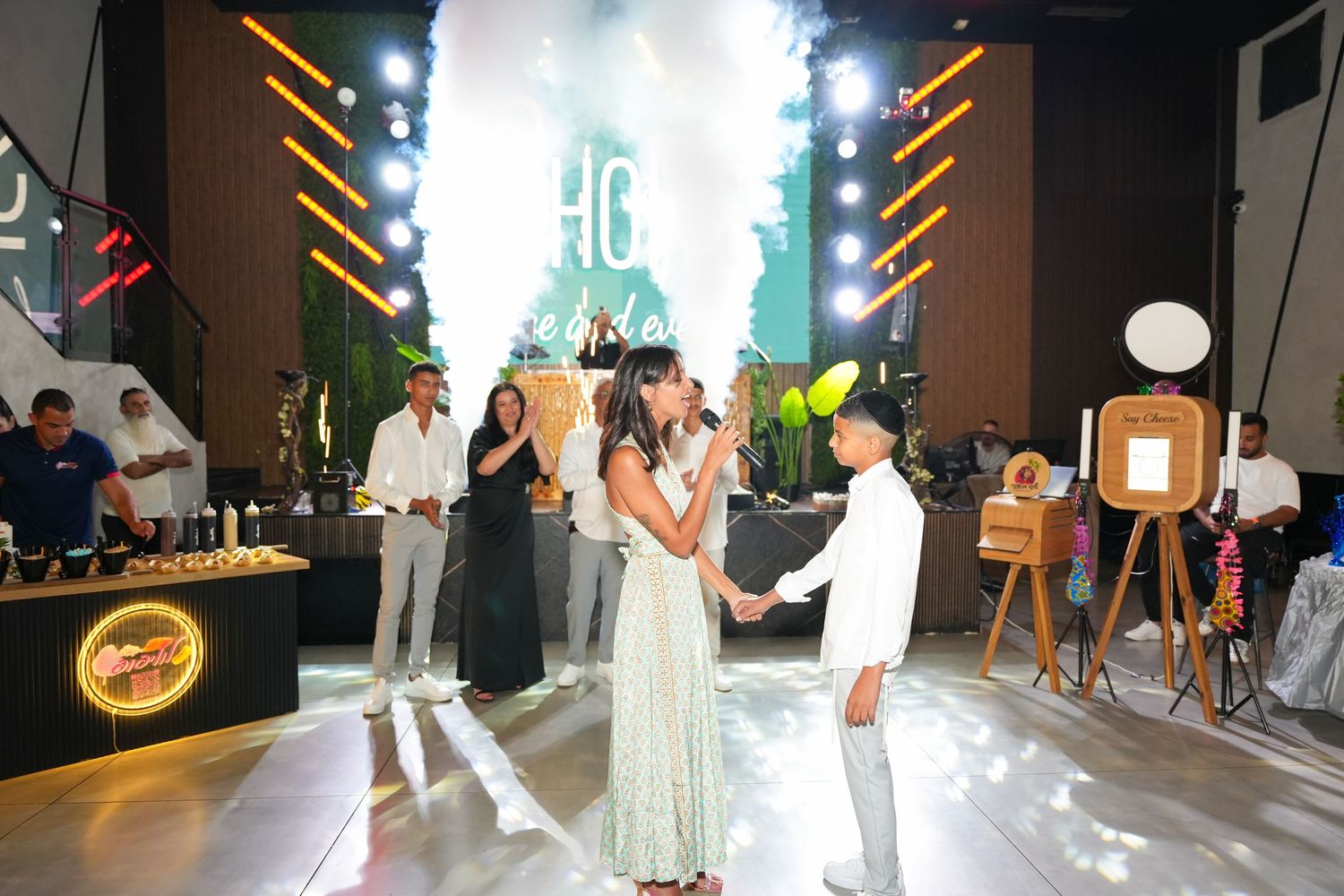 Modern event space with dramatic lighting and people gathered for a celebration.