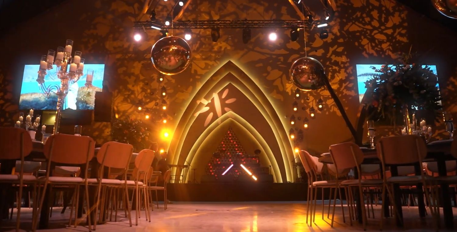 Nighttime outdoor venue with gothic arched architecture and ambient lighting.