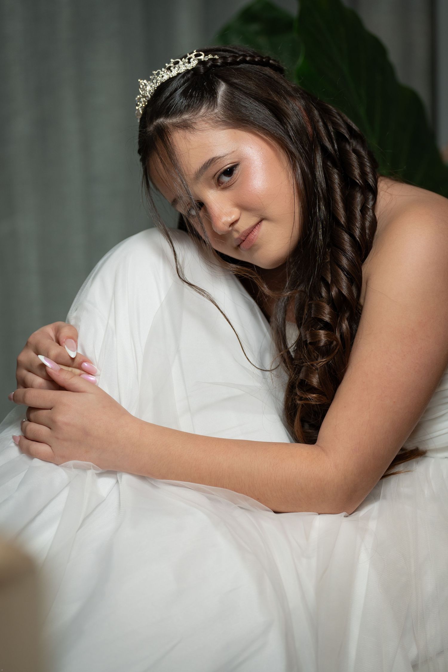 A series of soft, dreamy boudoir photos showing a person resting on white bedding in romantic lighting.