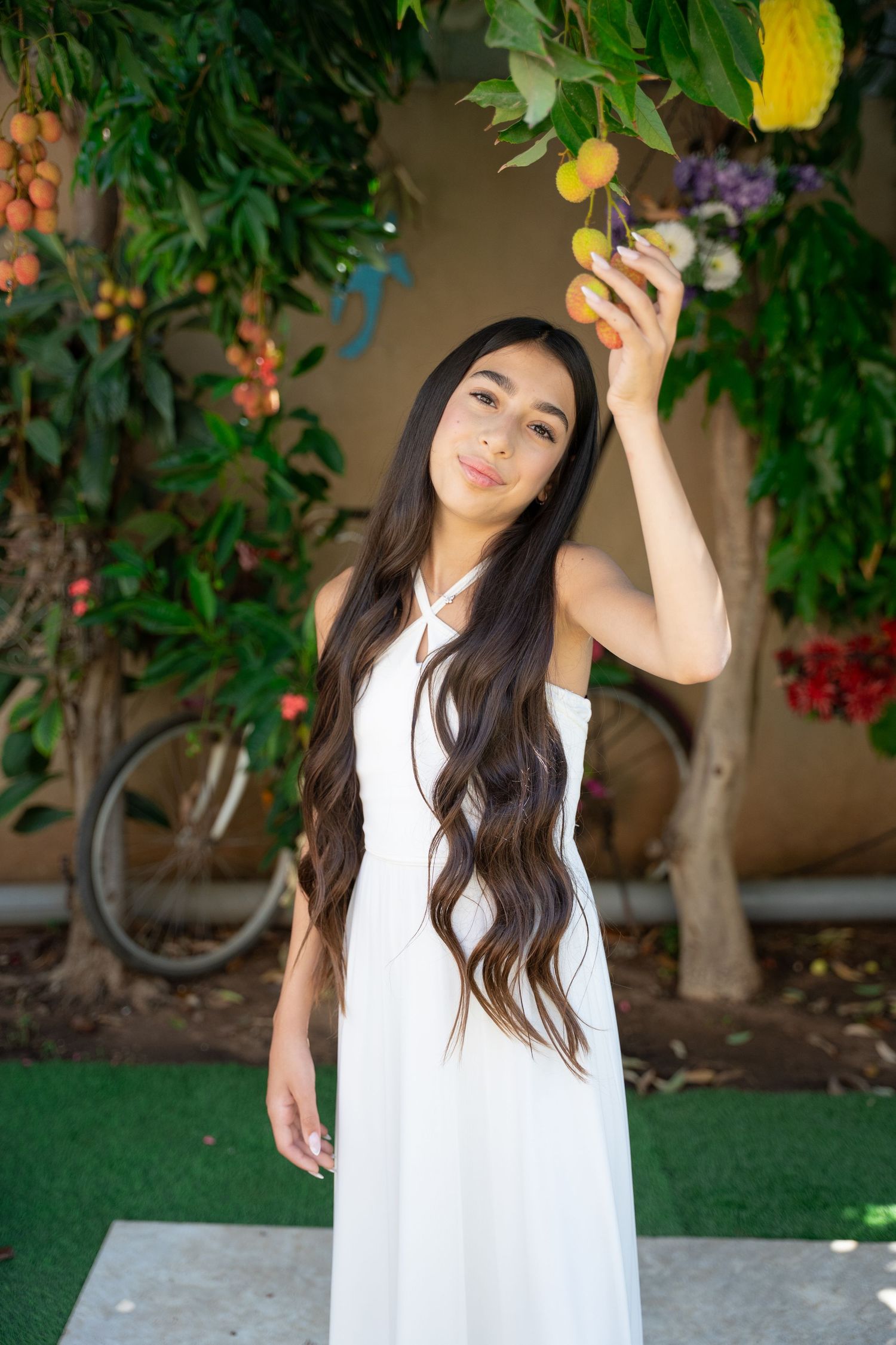 A white dress photoshoot in a garden setting with fruit trees and natural lighting.