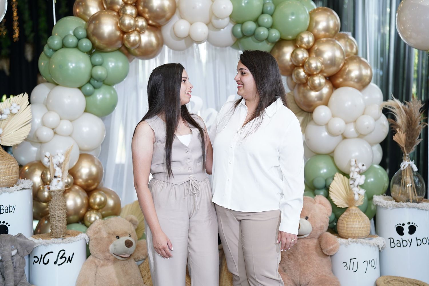 Baby shower celebration area with balloon garland and plush teddy bears on display.