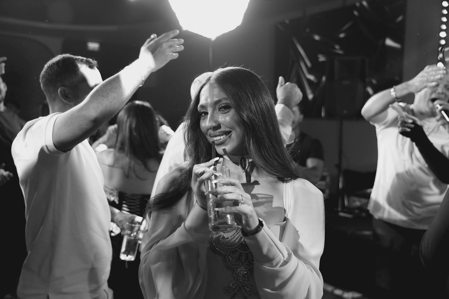 Black and white photo collage showing people dancing and celebrating at what appears to be a wedding reception or party.