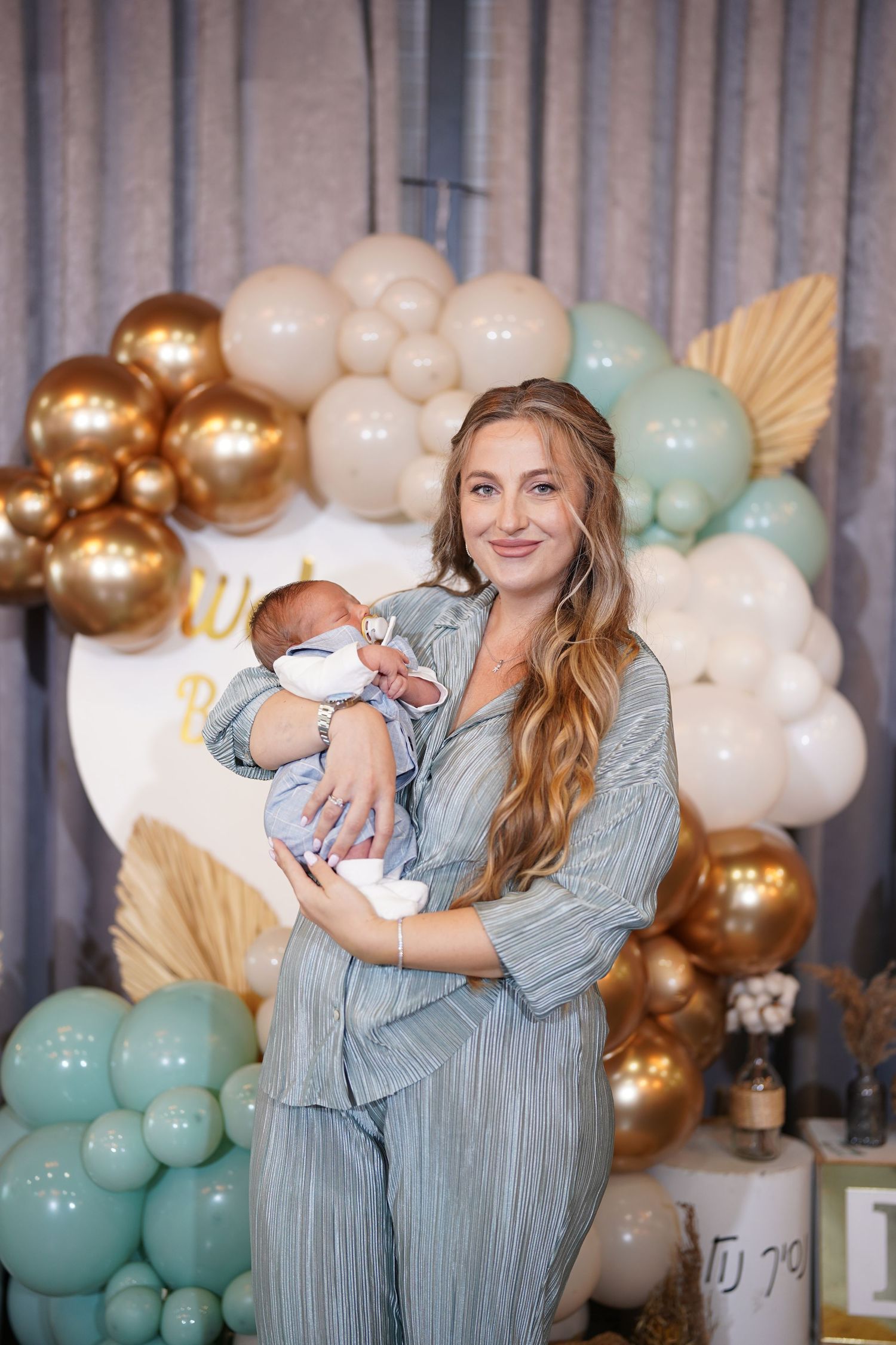 Sweet interaction at an elegant baby shower with balloon garland and decorative elements.