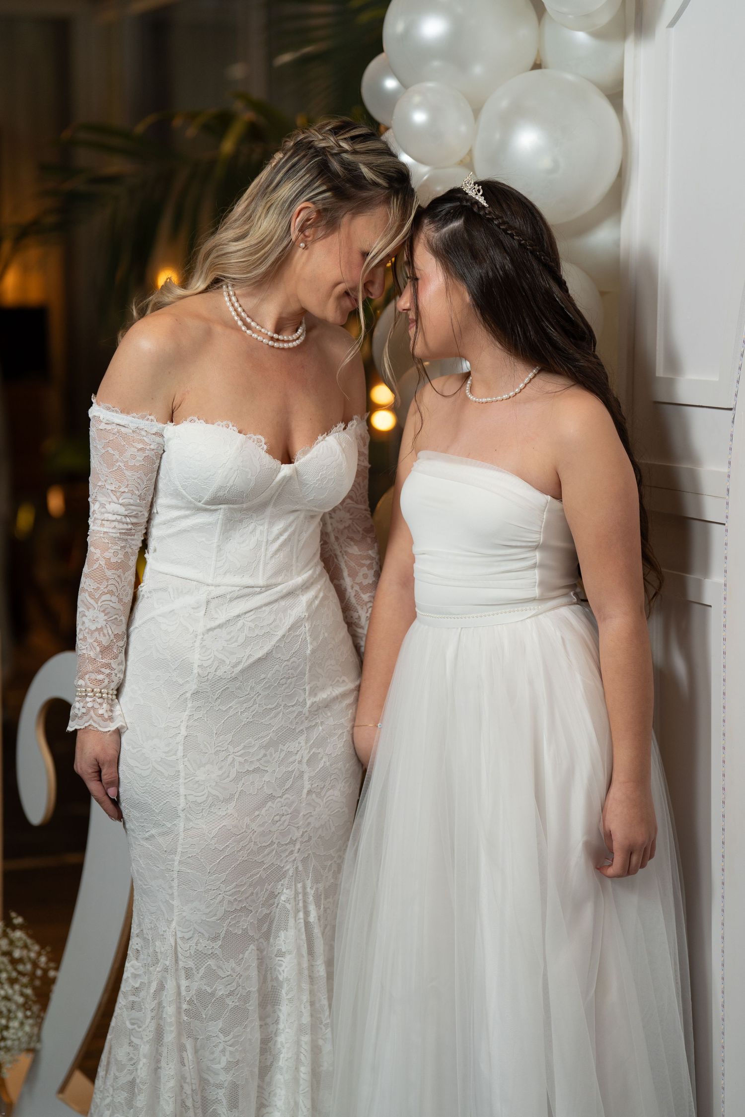 Two people in white wedding dresses share an intimate moment together during their wedding celebration.