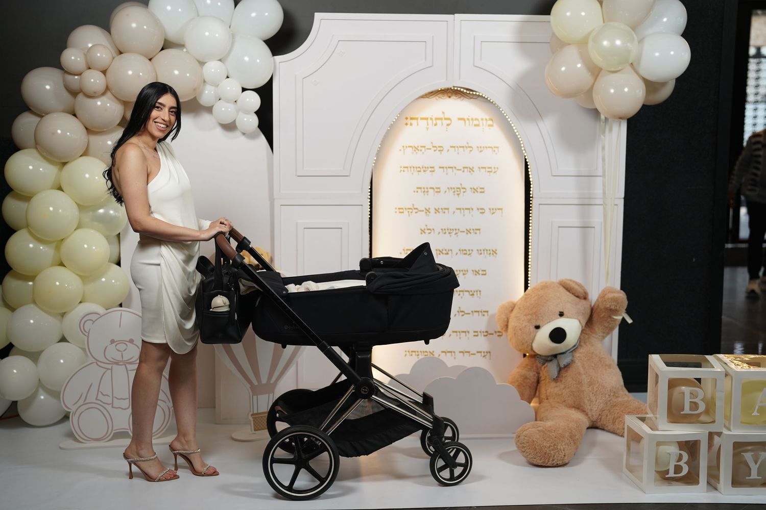 Baby photography studio with stroller, balloon decorations, and neutral-colored props.