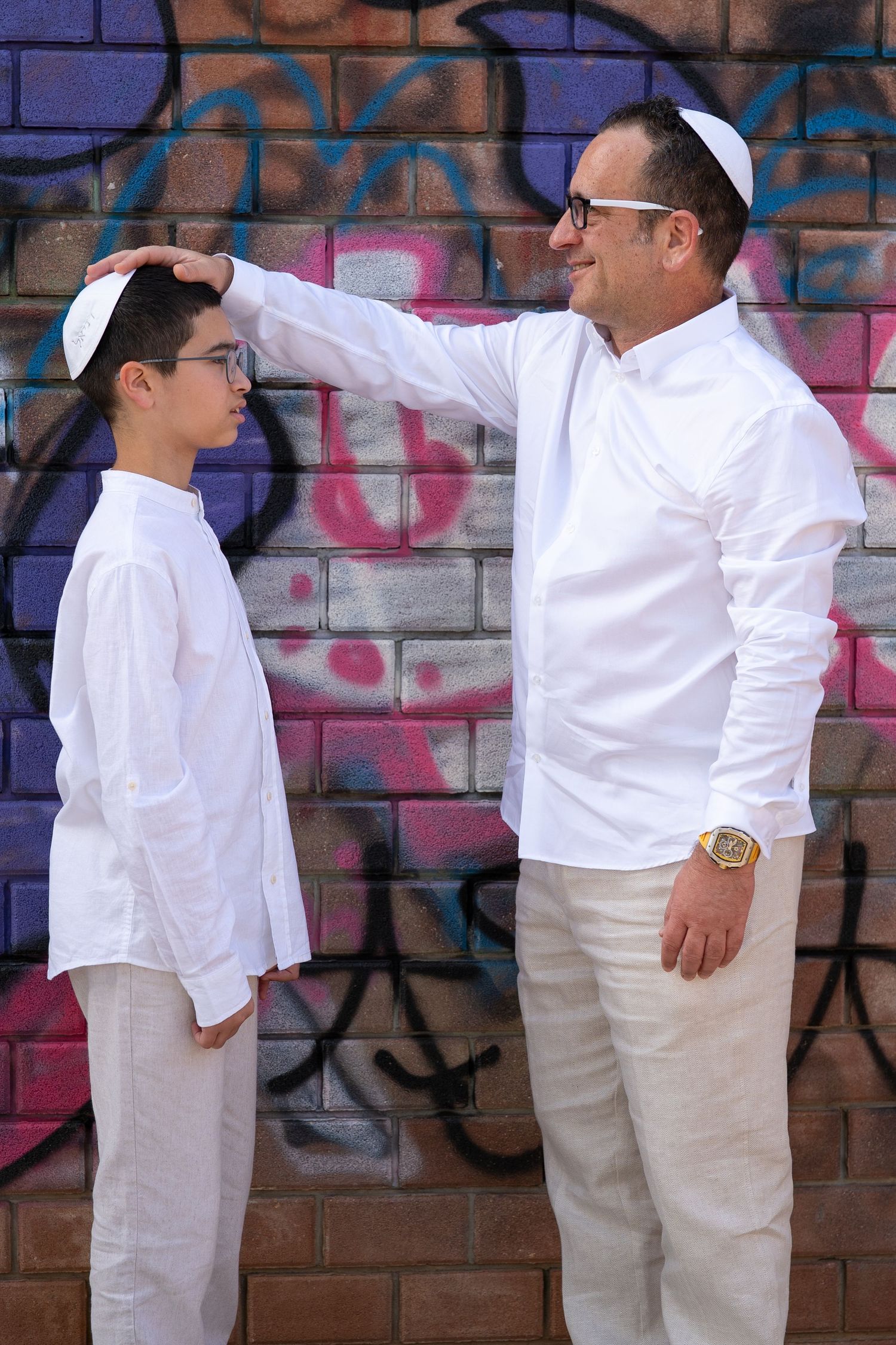 Group wearing all white poses against graffiti wall for creative photo series.