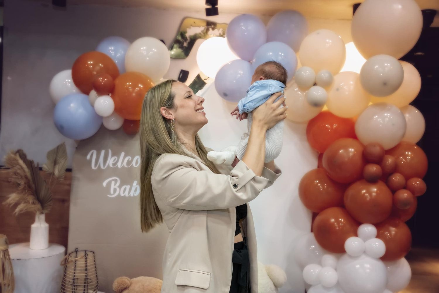 Festive balloon arch display in orange and white colors at an event.