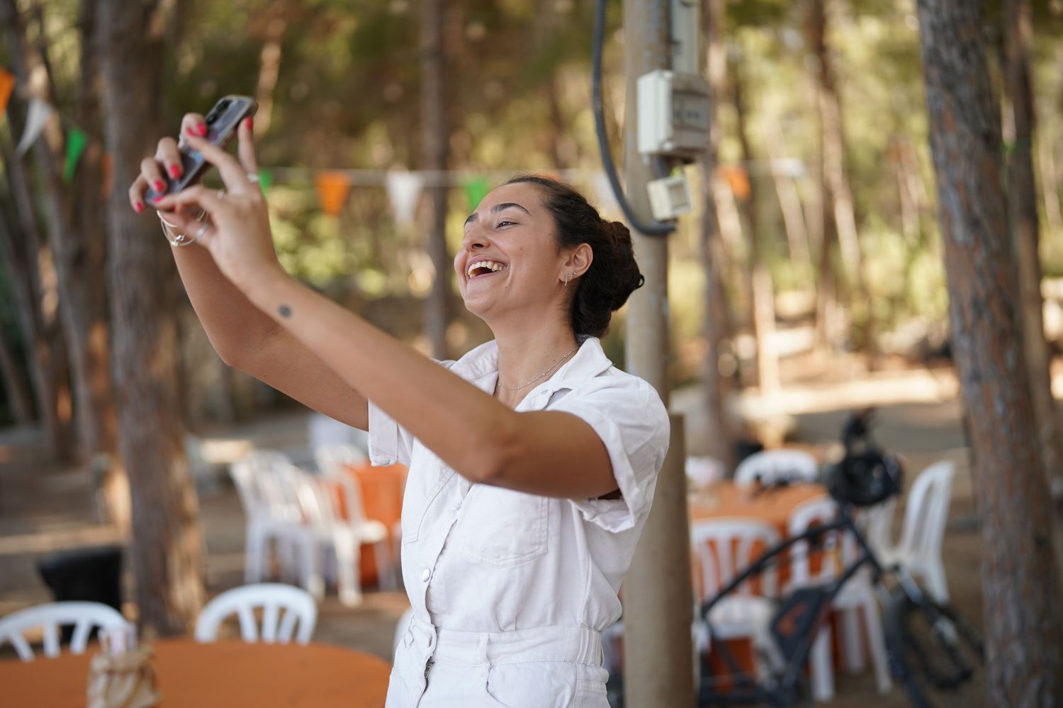Person enjoying an outdoor celebration with joyful expressions and natural lighting.