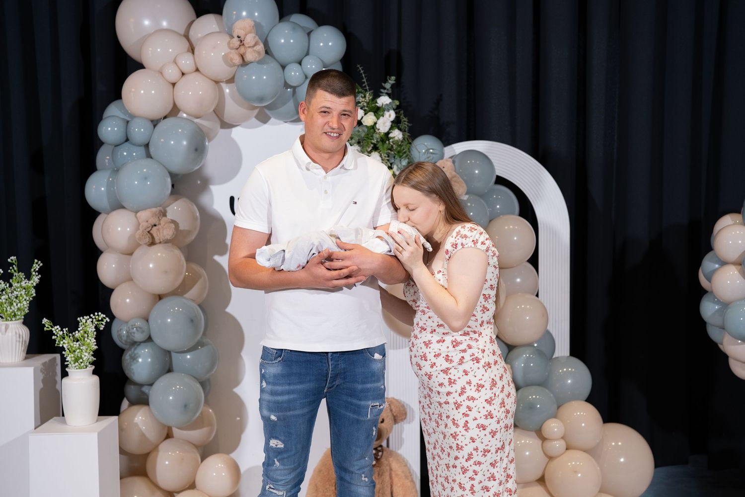 Maternity photoshoot with balloon decorations and welcome baby signage.
