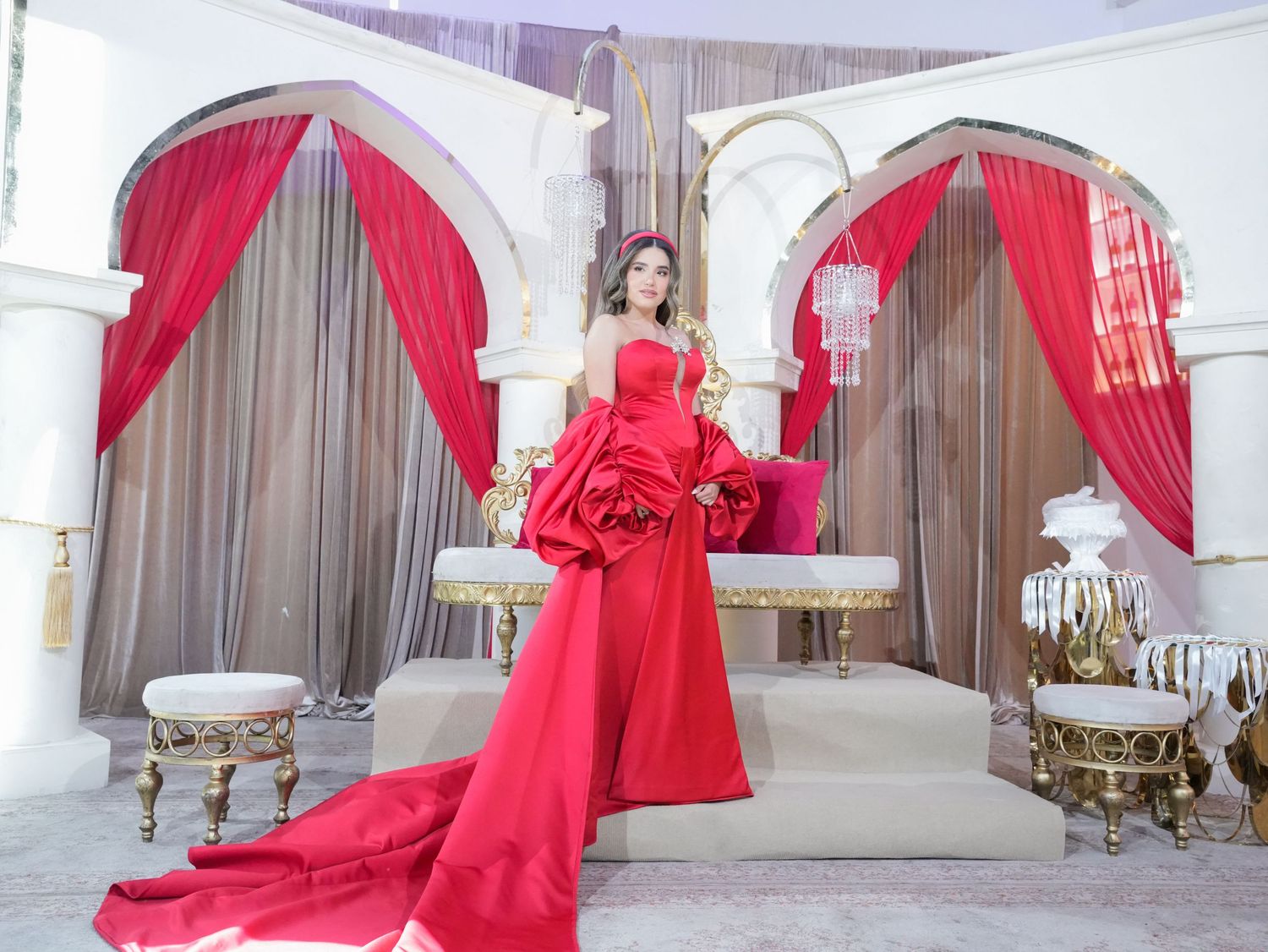 Flowing red dress captured in a series of glamorous poses against white interior.