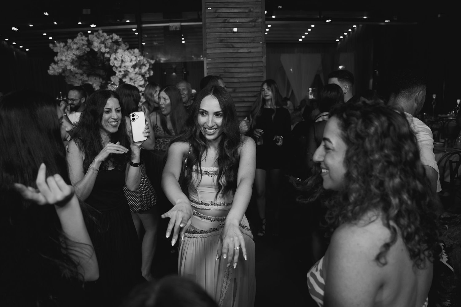 Black and white photo of women dancing and celebrating at an elegant party or wedding reception.