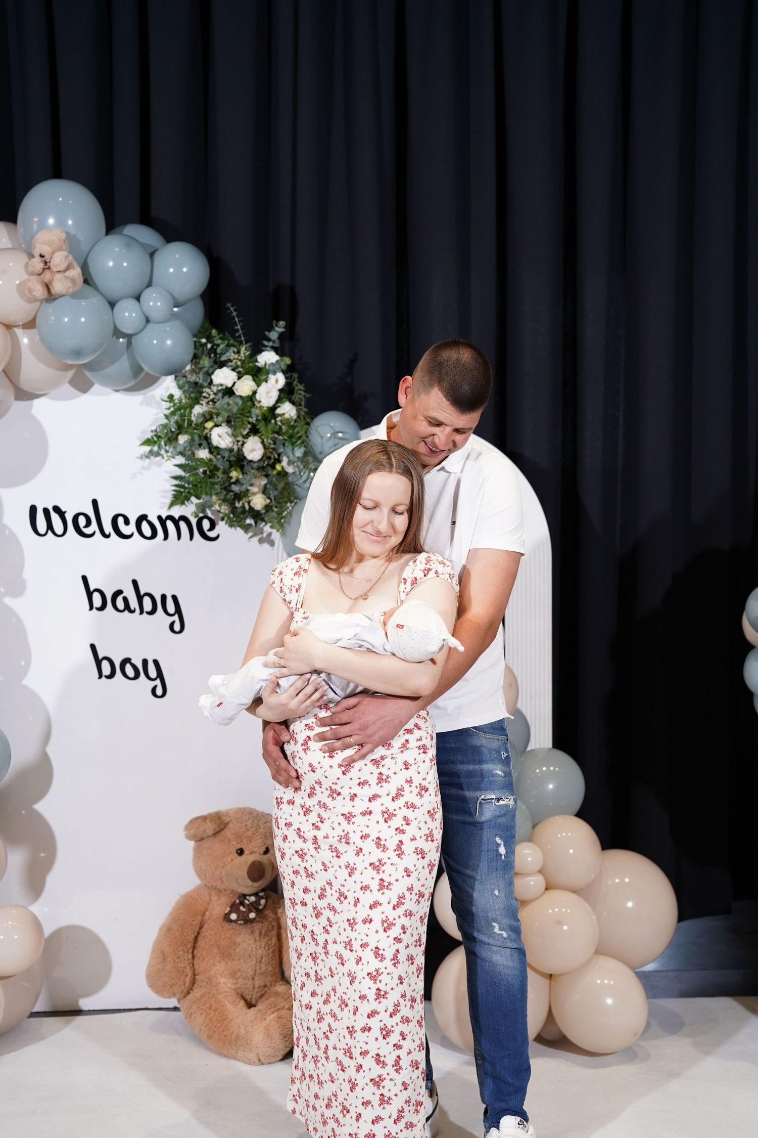 Baby shower setup with balloon arch, welcome signs, and teddy bear decorations.