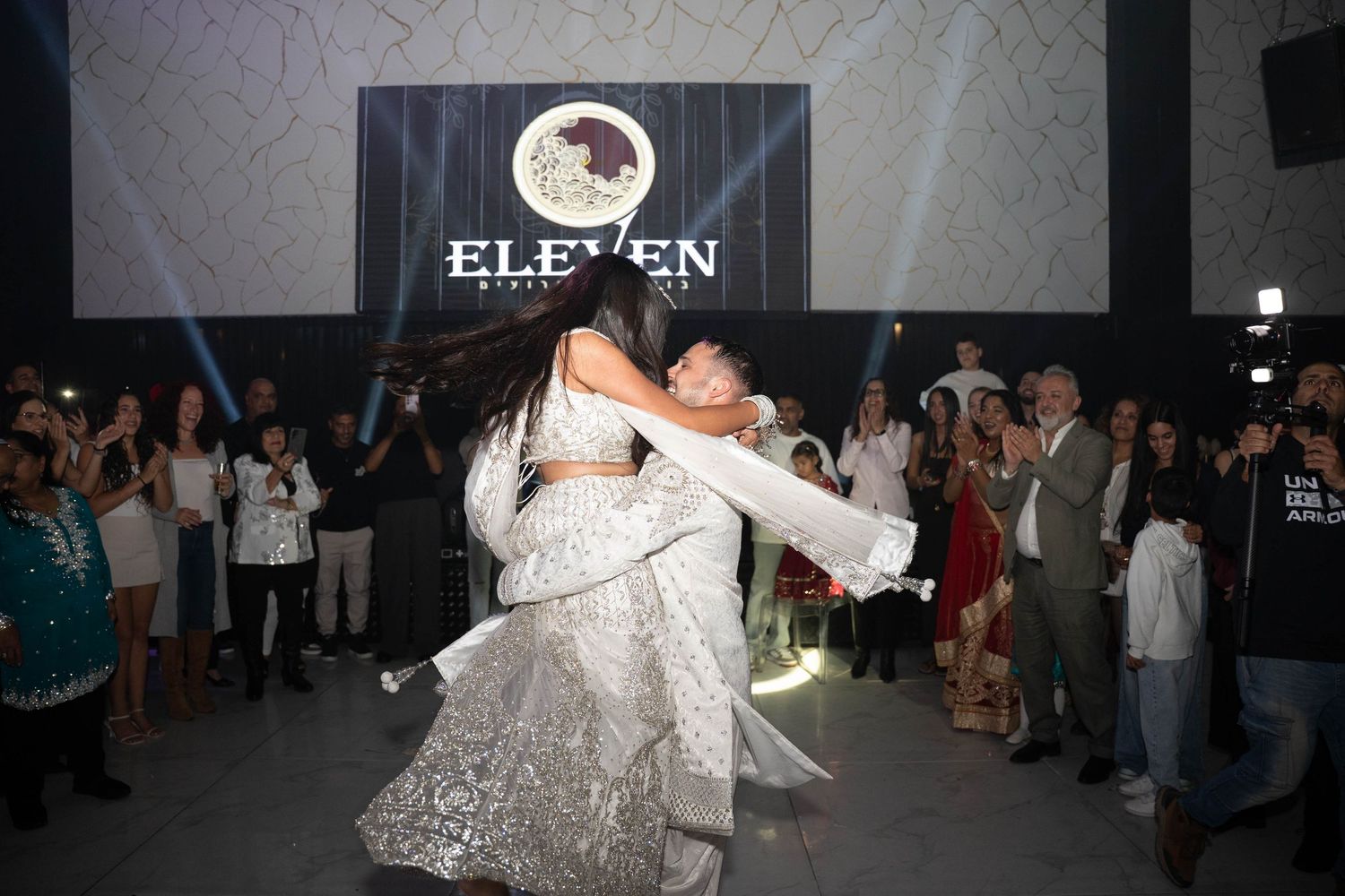 Elegant wedding celebration with colorful lighting effects and smoke on a dance floor.