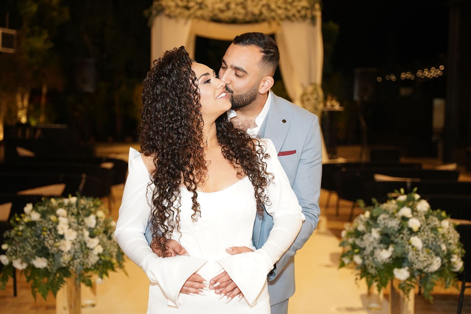 Wedding celebration at night with floral decorations and romantic lighting.