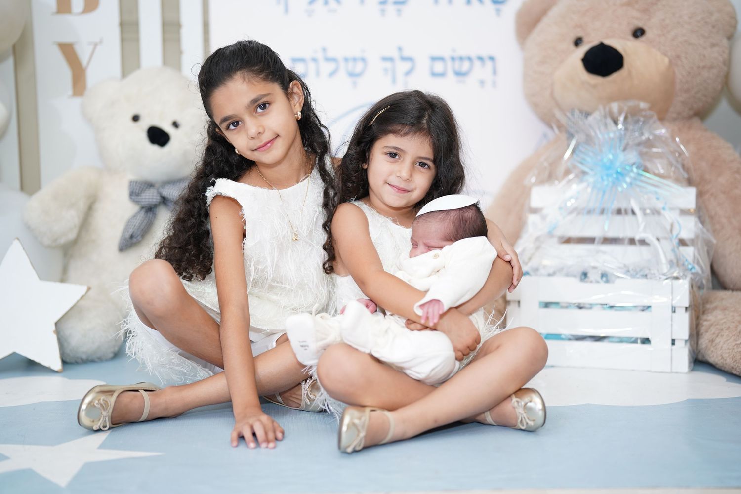 Children pose together during family photoshoot with teddy bear decorations.